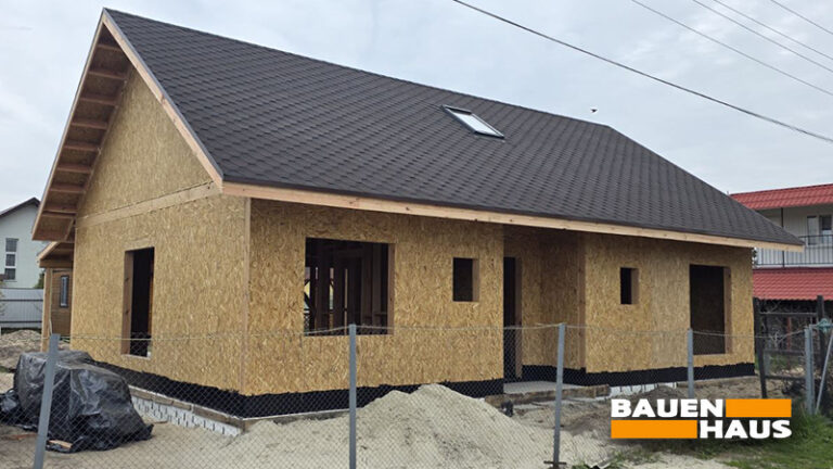Кутовий ракурс СІП-будинку за проєктом «Конвалія» 87 м² після завершення монтажу коробки, покрівлі та підготовки до наступних етапів будівництва